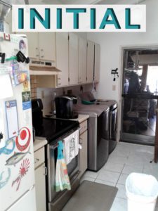 A kitchen with white cabinets and black appliances.