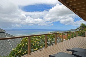 A deck with chairs and a view of the ocean.