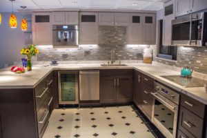 A kitchen with tile floors and a stove top oven.