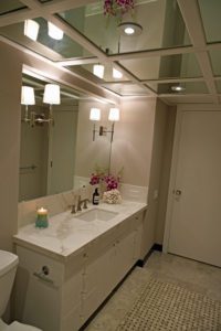 A bathroom with a sink, mirror and candles.