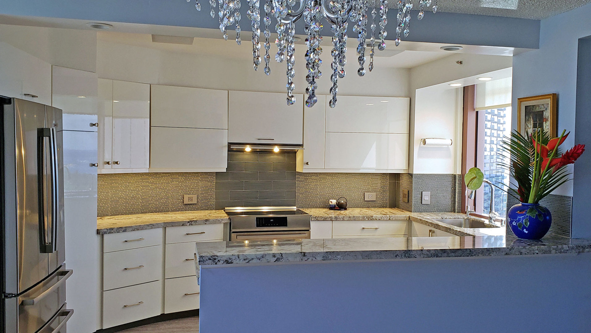 A kitchen with white cabinets and a large island.