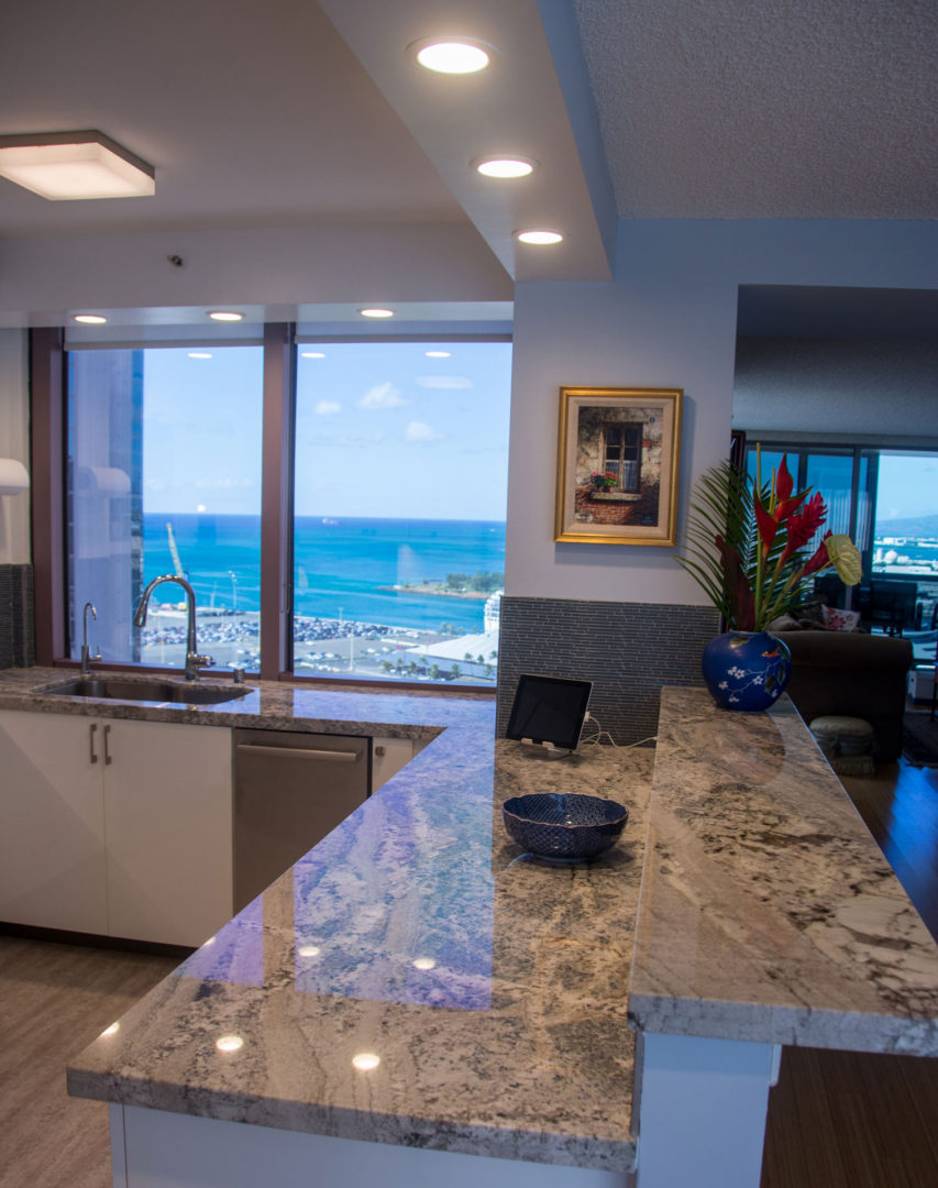 A kitchen with a large window and a view of the ocean.