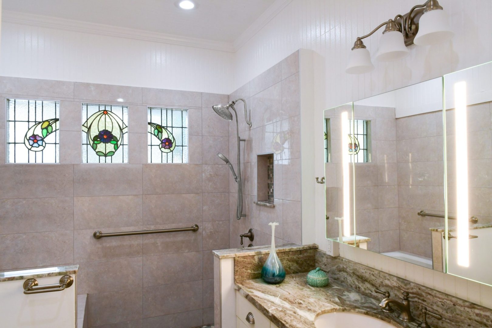 A bathroom with marble counter and shower stall.