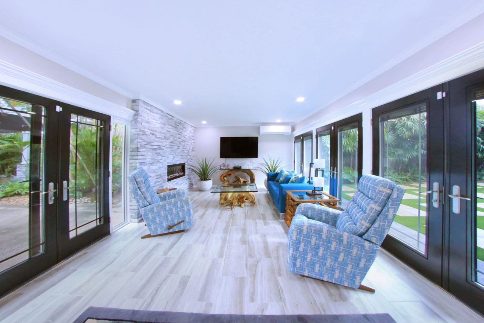 A living room with blue chairs and a fireplace.