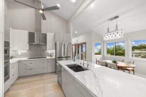 A kitchen with white cabinets and a large island.