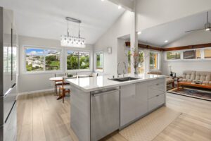 A kitchen with white cabinets and wooden floors.