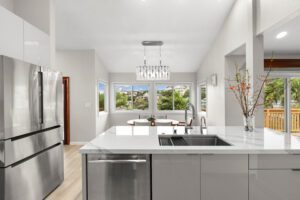 A kitchen with a sink, dishwasher and refrigerator.
