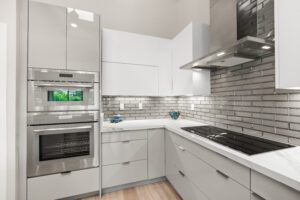 A kitchen with white cabinets and brick walls.