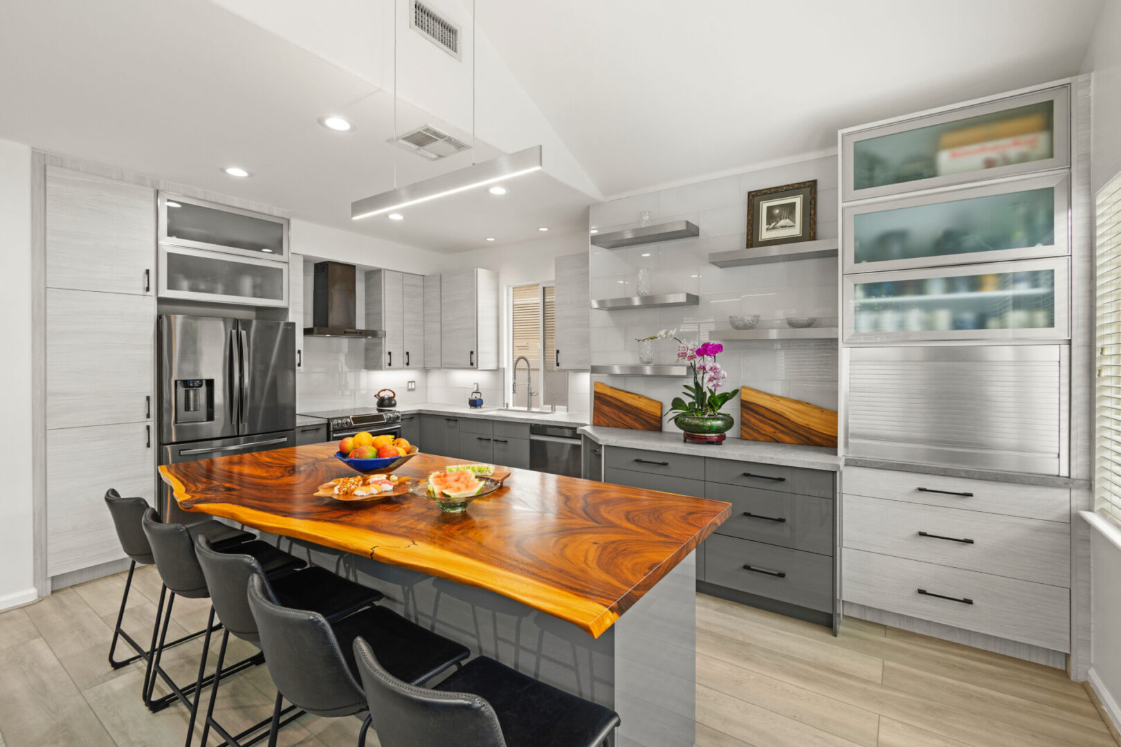 A kitchen with a large island and wooden counter top.