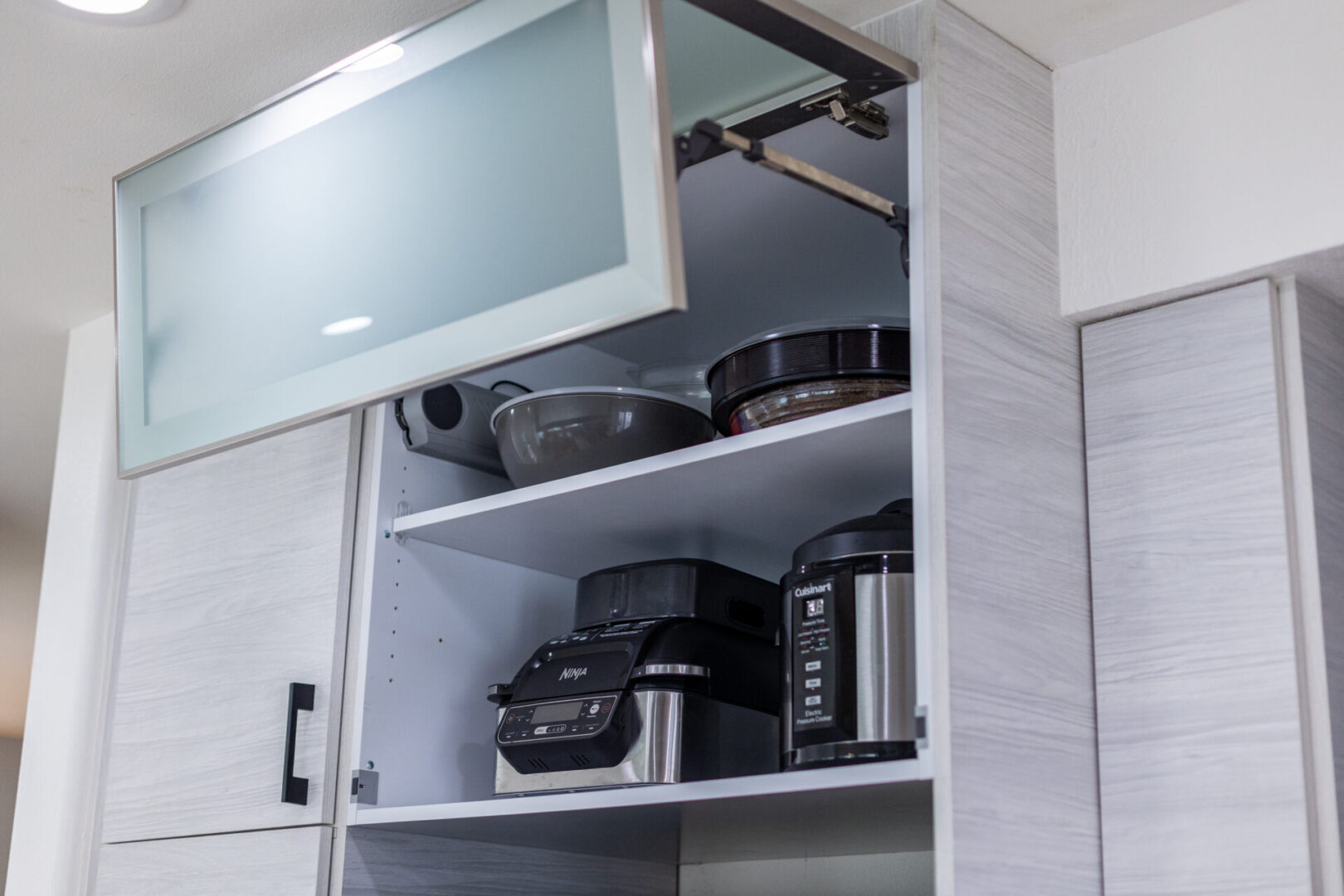 A kitchen with many pots and pans on the shelves.