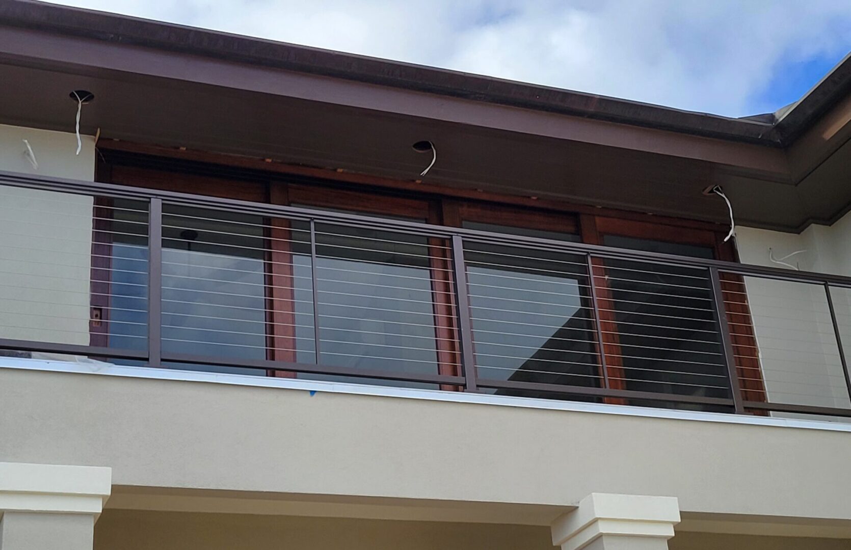 A balcony with metal railing and glass panels.