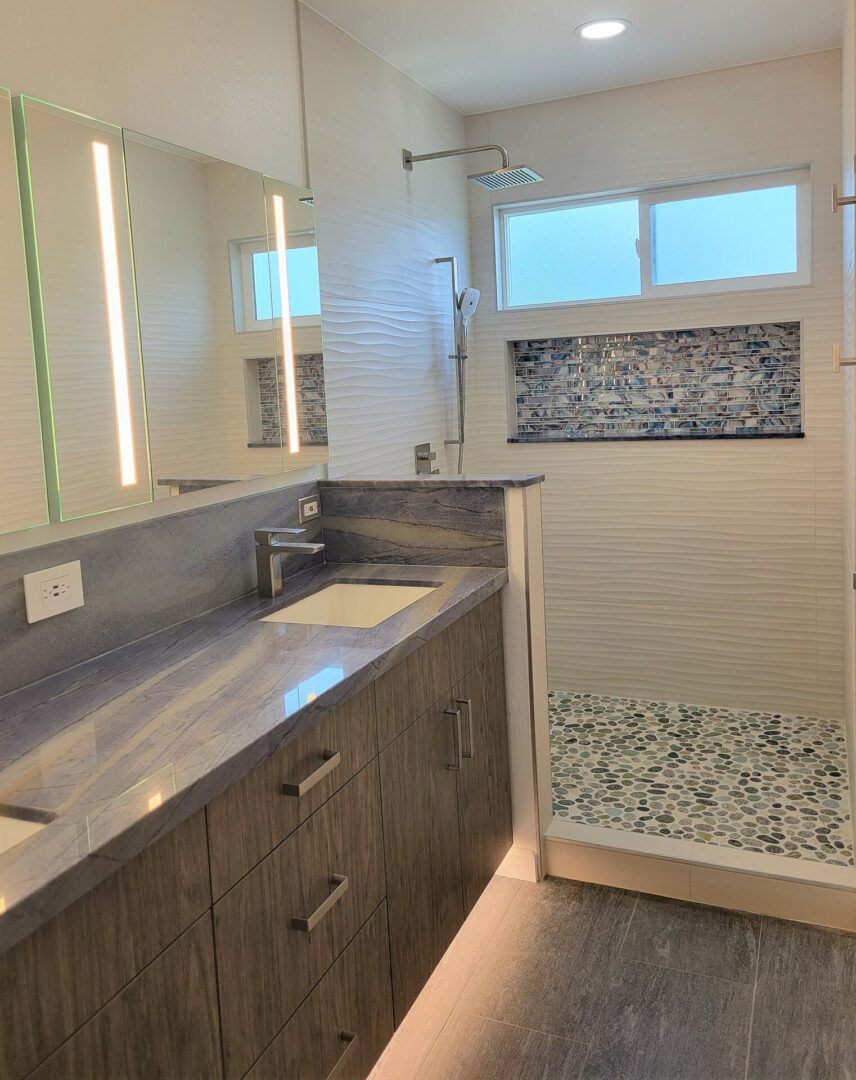 A bathroom with a sink, mirror and shower.