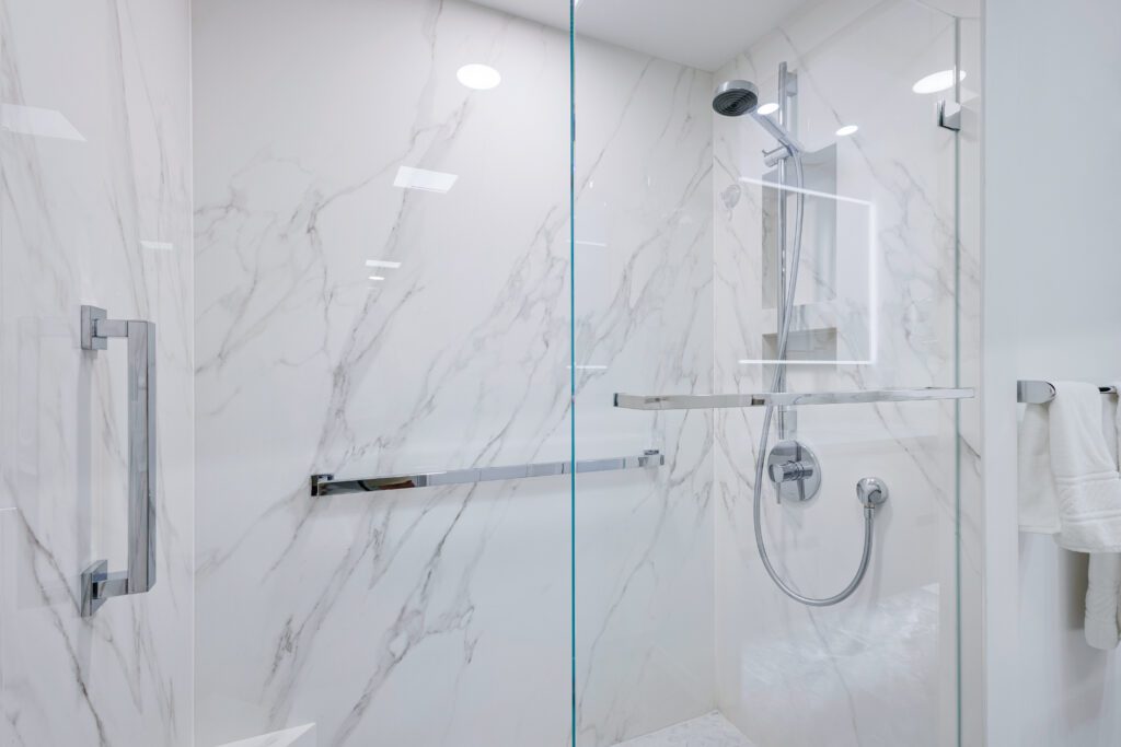 Modern glass shower with marble walls.