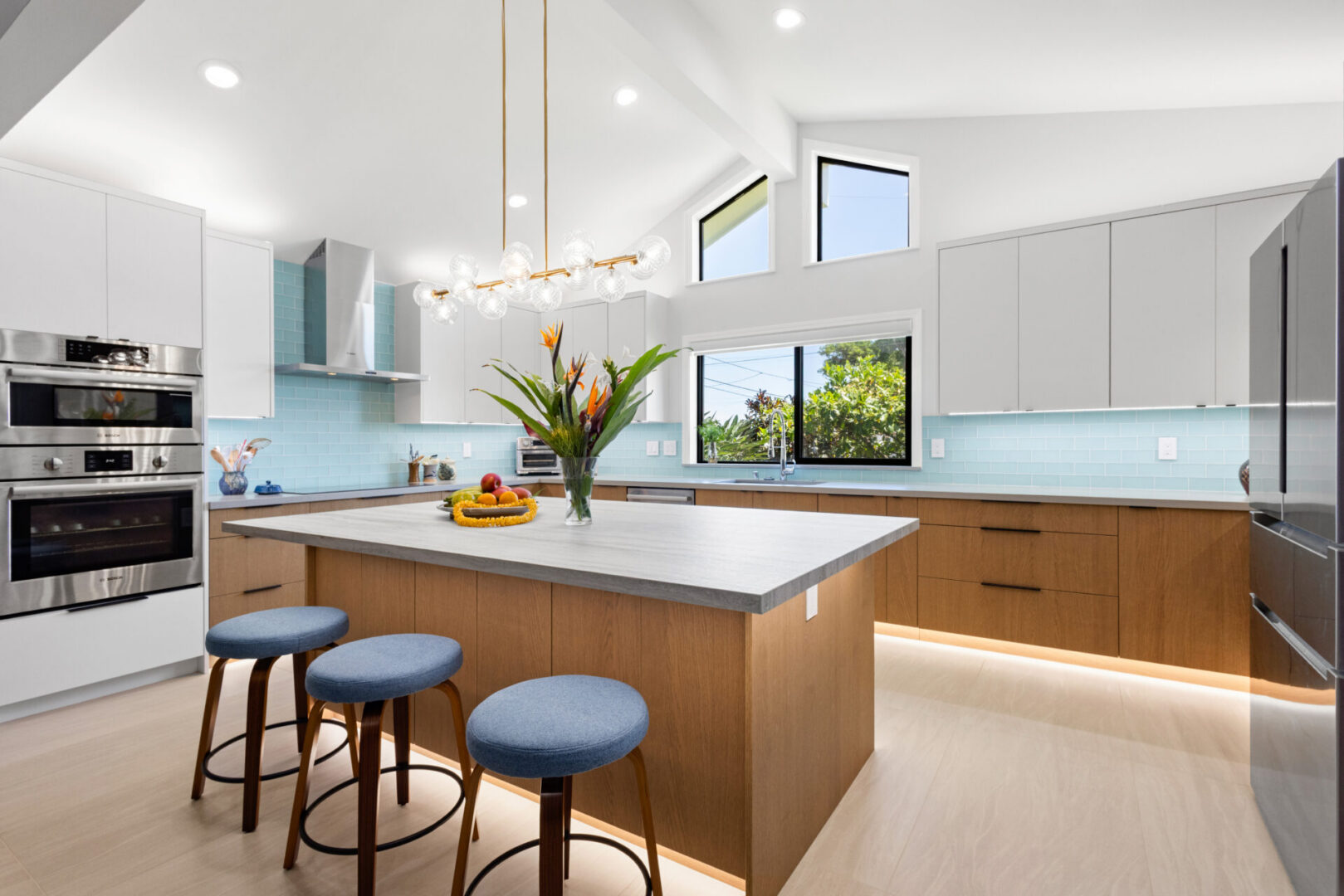 Bright modern kitchen with island and blue stools